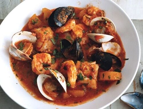 Schale mit katalanischem Fischeintopf, Garnelen und Muscheln in Tomatensauce