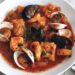 Schale mit katalanischem Fischeintopf, Garnelen und Muscheln in Tomatensauce