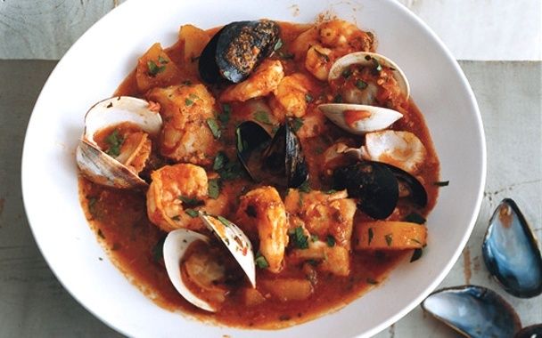 Schale mit katalanischem Fischeintopf, Garnelen und Muscheln in Tomatensauce